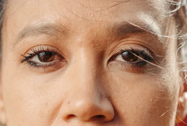 Personne appliquant un soin autour des yeux pour atténuer les poches